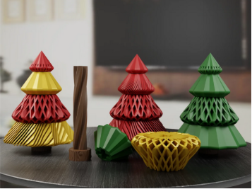 Four 3D printed Christmas tree models in red, yellow, and green, displaying intricate spiral vase and passthrough geometric design patterns.