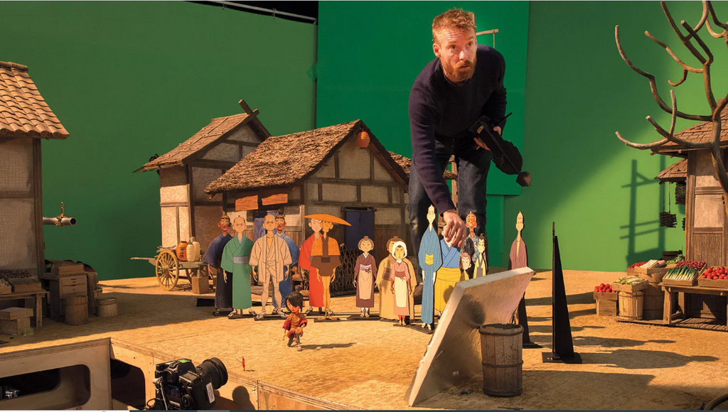 stop-motion animator carefully adjusting a miniature character on the highly detailed village set of Kubo and the Two Strings