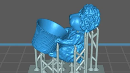 A slicer software preview showing a blue 3D model of a monkey character held up by grey tree-like support structures
