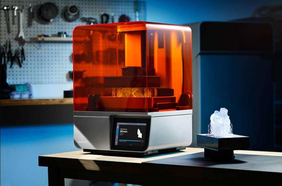 Formlabs Form 4 industrial resin 3D printer on a workbench beside a printed medical part