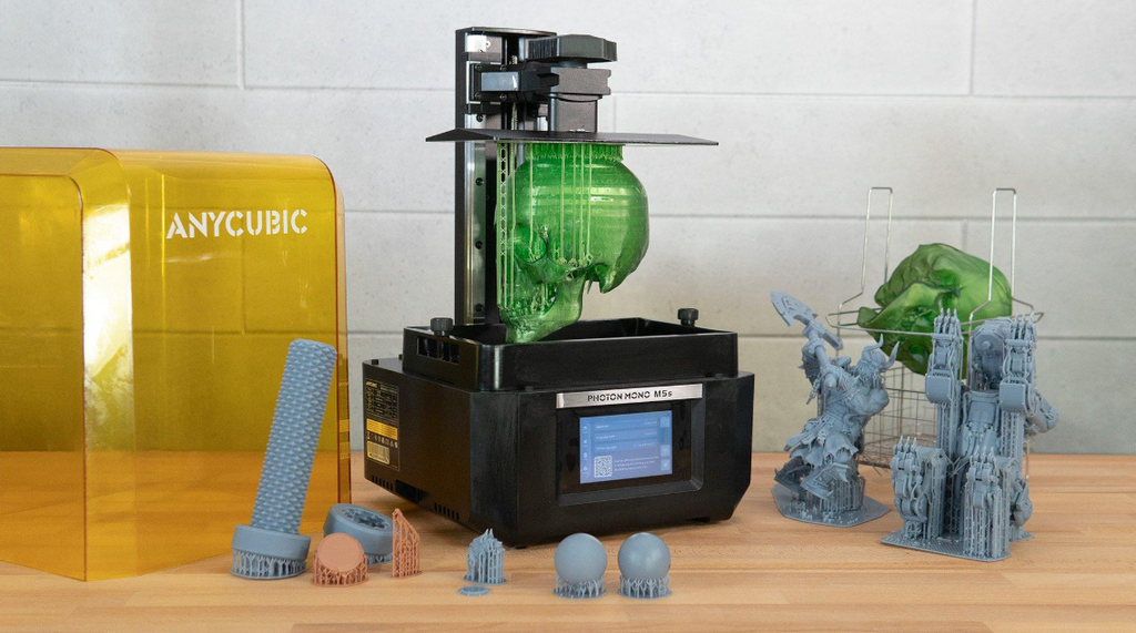 Anycubic Photon Mono M5s 3D printer actively printing a green skull on a workshop bench