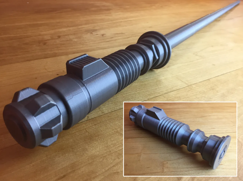 A silver 3D-printed collapsible basket mechanism shown in both its extended, wand-like closed form and its partially opened, self-supporting state
