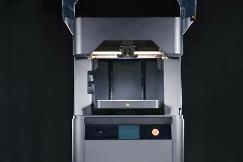The Markforged Metal X extrusion-based metal 3D printer displaying its internal print bed through an open viewing window.