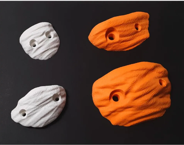 Four textured 3D-printed crimp climbing holds two in white and two in bright orange