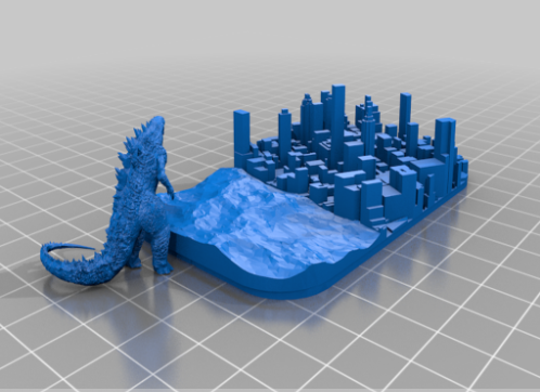 A blue 3D printed diorama featuring a miniature Godzilla figure looming over a detailed urban cityscape.