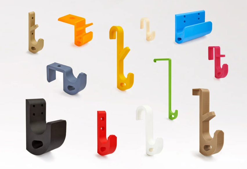 A collection of 3D printed U-hooks in various bright colors, sizes, and configurations, demonstrating the design's universal adaptability.
