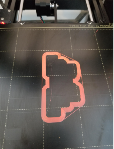 pink outline shape printed on a black heated steel sheet on a Prusa 3D printer bed.