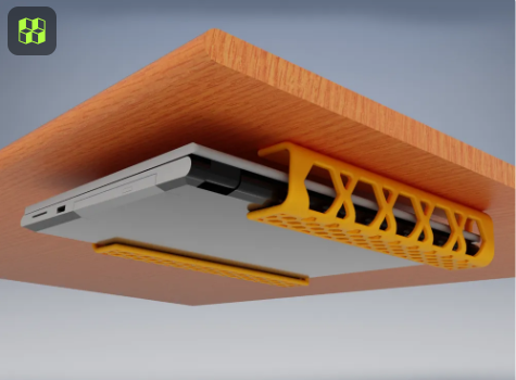 A silver laptop suspended under a wooden desk using two orange 3D-printed mounting brackets to free up surface space.