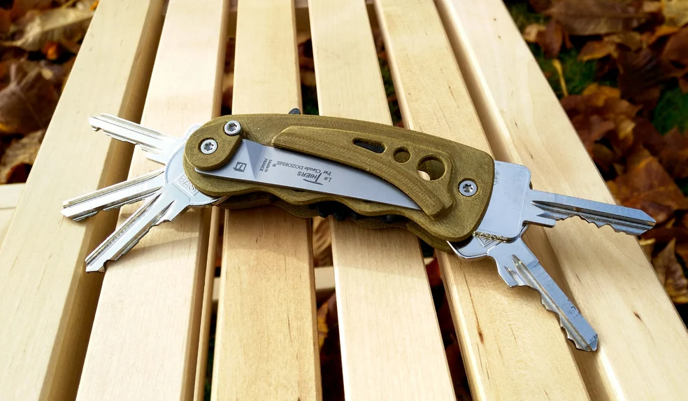 A 3D-printed, gold-colored pocket key organizer that incorporates a Thiers pocket knife blade alongside several keys.