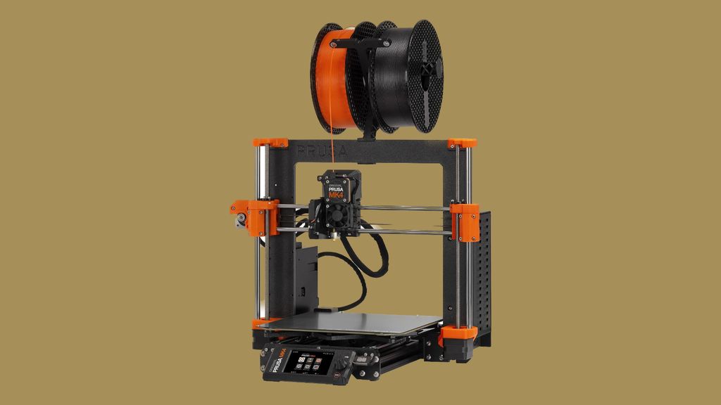 Orange and black Prusa i3 MK4 desktop 3D printer with a dual filament spool holder mounted on top.