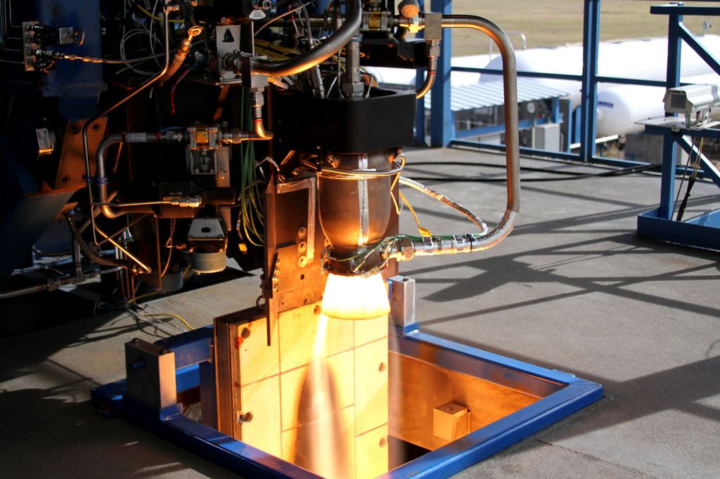 A specialized 3D printing machine at a SpaceX facility actively fabricating a metal rocket component using additive manufacturing technology.