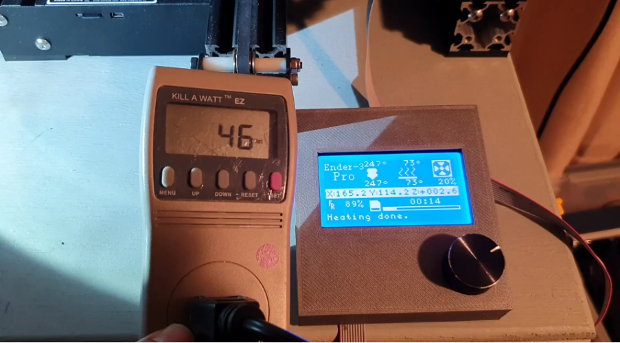 A digital energy meter connected to a 3D printer, displaying a real-time power reading of 46 watts during operation