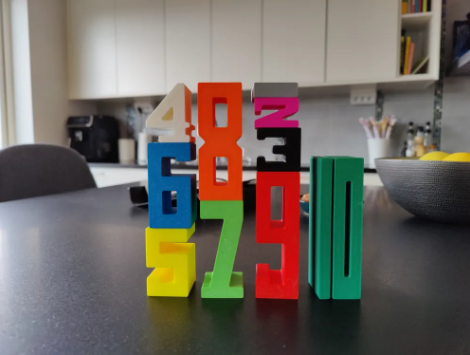 Colorful 3D-printed number blocks stacked proportionally to teach basic arithmetic and magnitude.