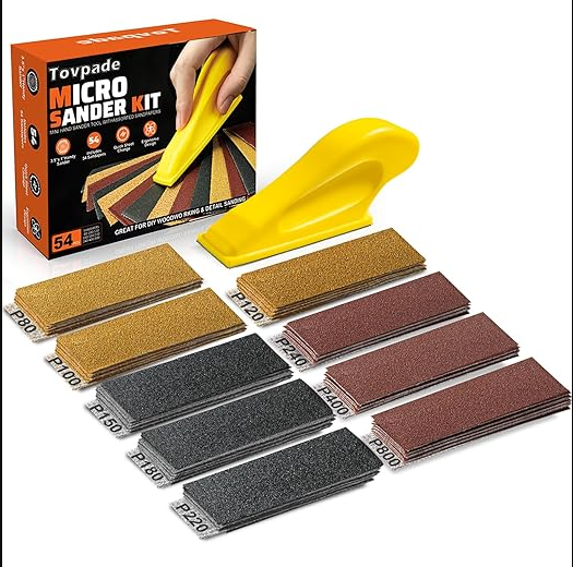 A yellow micro hand sander tool laid out next to multiple strips of assorted grit sandpaper.  