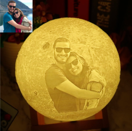 A glowing, 3D printed lithophane moon lamp featuring a personalized photo of a couple.