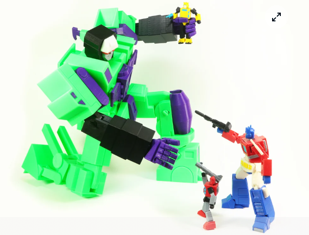 A vibrant, multi-colored 3D printed articulated G1 Optimus Prime action figure, posing dynamically next to a larger green and purple printed mech.
