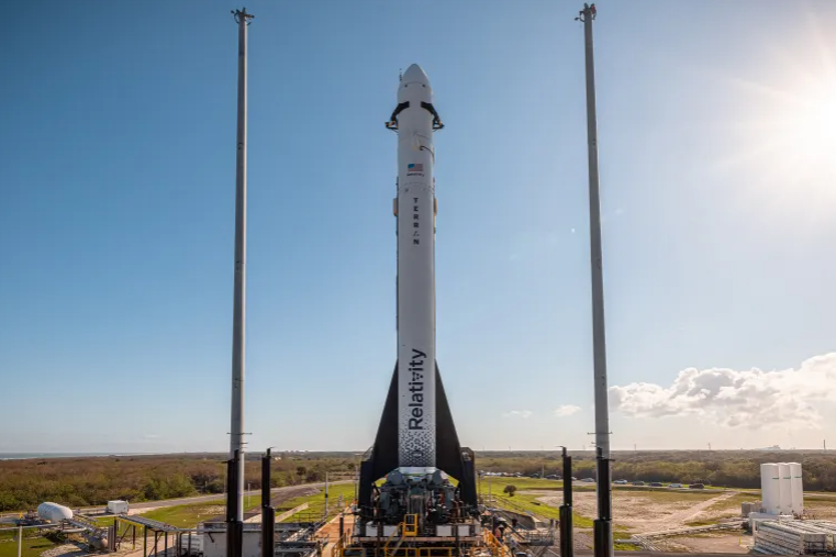 Relativity Space's Terran 1, the world's first largely 3D-printed rocket, standing tall on the launchpad at Cape Canaveral under a clear blue sky.