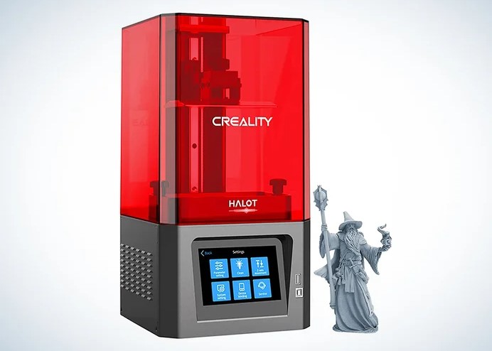 The Creality Halot-X1 resin 3D printer featuring a striking red UV cover and a front digital display, positioned next to a detailed grey 3D printed wizard miniature