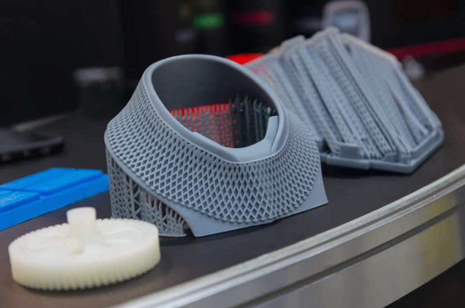 Grey precision 3D printed mechanical parts and gears displayed on a table