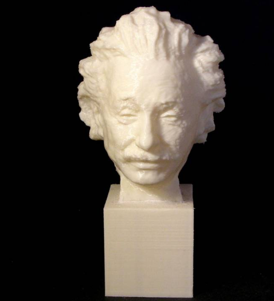 A white 3D-printed bust of Albert Einstein resting on a square pedestal against a dark background.