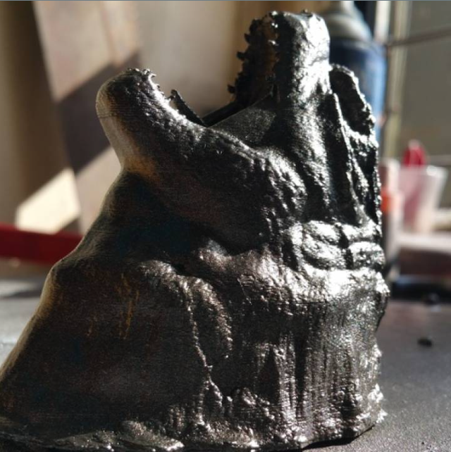 A glossy black 3D printed Godzilla head roaring, designed as a dramatic, taxidermy-style wall mount.