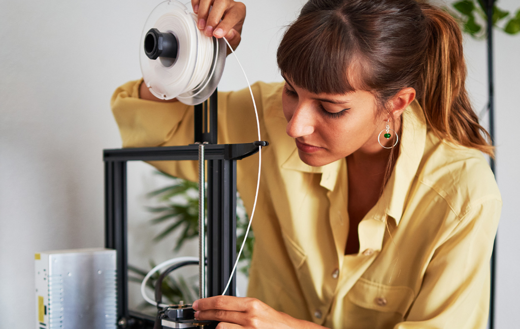 A woman supervising a 3D printer