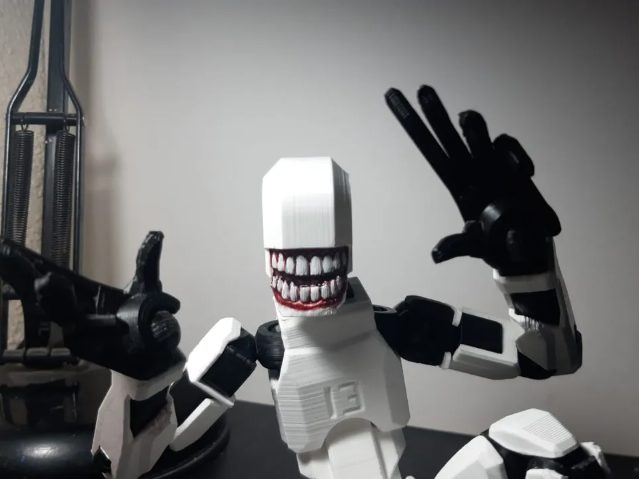 3D-printed white Dummy 13 articulated figure with a creepy monster smile.