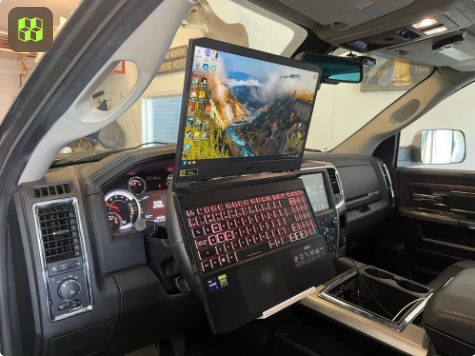 A laptop resting on a 3D-printed steering wheel holder inside a vehicle, designed to create a mobile office for digital nomads.