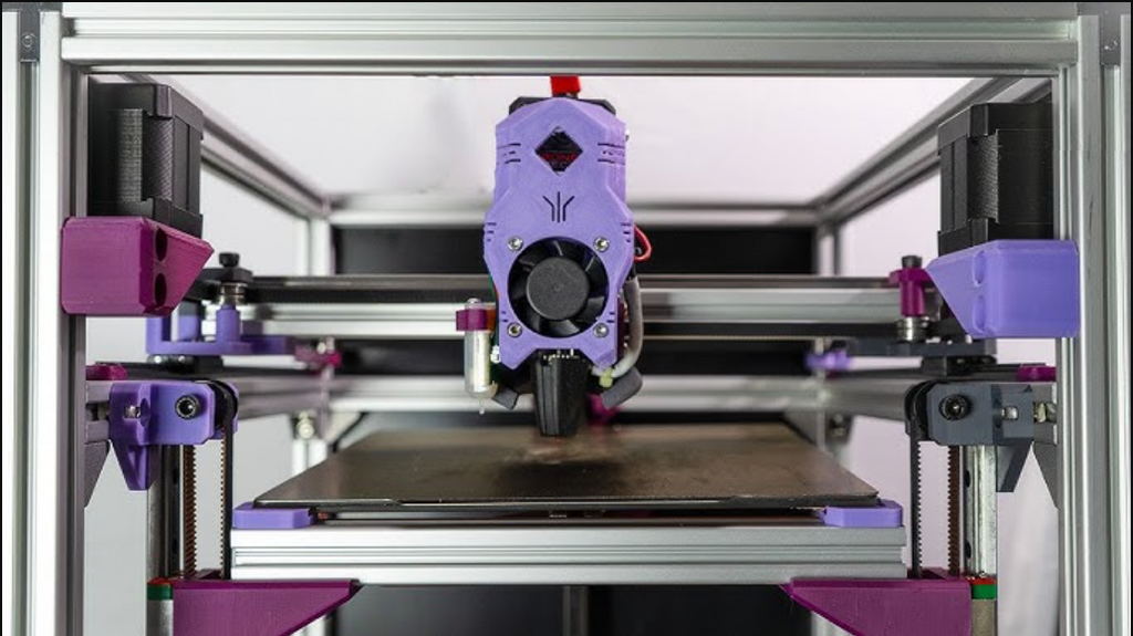 Close-up of a purple CoreXY 3D printer print head moving rapidly across the build plate to demonstrate high print speeds.